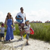 Familie onderweg naar het strand